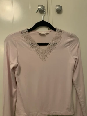 Spets tröja - Jag säljer en långärmad tröja från Ginatricot. Tröjan är v-ringad och har spets detaljer med små hjärtan. Skicka gärna frågor.😊🫶🏻