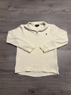Ralph Lauren 1/4 zip - Säljer denna sjukt snygga vita Ralph lauren 1/4 zipen. Den är galet snygg och höjer din look till en vanlig vardag! Den passar allt! Enda defekten är super liten fläck vid bakdelen på höger axeln. Kan gå bort i en tvätt. Det är storlek ( L 14-16) men det motsvarar storlek S i herr!  Hör av dig vid fundering!🤔  Fraktas samma dag som köp!📦
