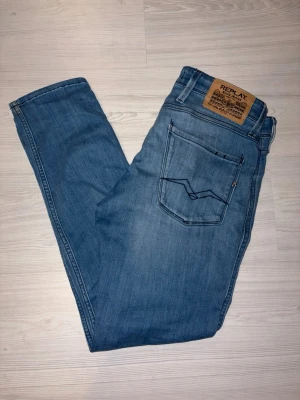 Replay anbass - Snygga blå jeans från Replay i klassisk femficksmodell. Jeansen har raka ben, ljus tvätt och detaljerade bakfickor med kontrastsömmar. Tillverkade i mjukt denimtyg med Replay-lapp bak i midjan. Perfekta för en avslappnad och trendig look.