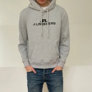 J.Lindeberg Grå Hoodie - Säljer en sjukt fet hoodie från J.Lindeberg. Hoodien är i mycket bra skick utan nåra defekter och är färgen grå. Den är i strl L men sitter som en M! Hör gärna av er vid frågor elr funderingar!!