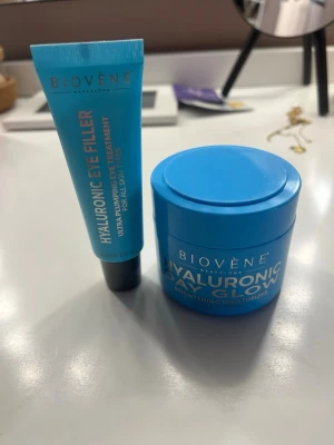 Biovène Hyaluronic Eye & Day Glow - Säljer ett set från Biovène med Hyaluronic Eye Filler och Hyaluronic Day Glow Brightening Moisturizer. Båda produkterna kommer i blå plastförpackningar och är perfekta för återfuktning och lyster till huden. Passar alla hudtyper och ger intensiv återfuktning. Aldrig använda 