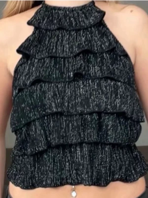 Svart/glittrig halterneck  - Snygg svart halterneck top med ribbad struktur och glitter. Helt oanvänd, endast testad. Har lappen kvar.