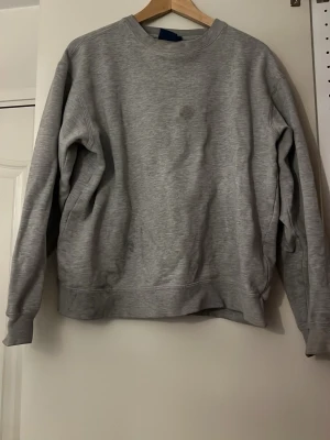 Grå basic hoodie i bomull - Enkel och stilren grå hoodie i mjuk bomull. Som tyvärr har två fläckar 