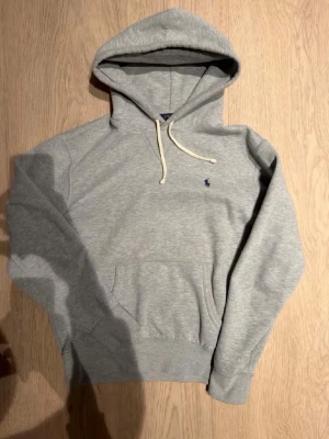 Grå Ralph Lauren hoodie - Säljer denna  grå hoodie från Ralph Lauren i storlek M passar större S | mått är ca 65 lång o 46 axel till axel | hör av er vid fler frågor!