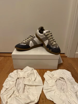 Maison Margiela GATS men färgstänk - Säljer nu dessa Maison Margielas med blått färgstänk på. Dom är storlek 40 och true to size. kvitto och allt og tillkommer. Dom är köpta hos merchsweden och är varsamt andvända och riktigt snygga. Kom privat om ni har fler frågor.