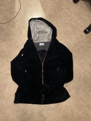 Svart hoodie med tryck och dragkedja - Säljer en svart hoodie från limitato i mjukt sammetstyg med dragkedja framtill och huva. Baksidan har ett stort svartvitt tryck med texten 'Float like a butterfly, sting like a bee'. Perfekt för dig som gillar streetstyle. Ny pris runt 2000!!!