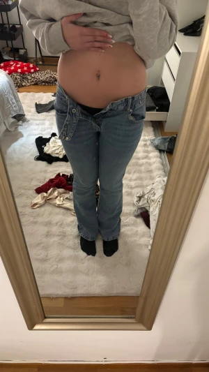 Blå bootcut jeans med låg midja - Säljer ett par klassiska blå bootcut jeans med låg midja och femficksmodell. Jeansen har en avslappnad passform och är perfekta för en chill och trendig look. Materialet är denim i bomull. Passar dig som gillar 00-talsstil.. använda några gånger men ser nya ut men säljs pågrund av att dom är för små i midjan 