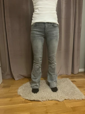 Grå lågmidjade bootcut jeans - Superfina gråa bootcut jeans i storlek 36/S från Gina tricot. Har inga skavanker eller liknande förutom några slitningar i benskutet(se bild). Dock absolut inget man ser när man har på sig dom så inget som syns. Nypris:500kr