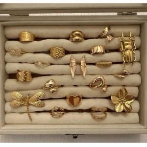 Unika guldfärgade ringar med motiv - Säljer flera guldfärgade ringar med olika former och motiv som hjärta, trollslända, blomma, insekt och abstrakta designer. Ringarna har en blank eller strukturerad yta och vissa har detaljer som fjädrar eller vågor. Perfekta för dig som vill sticka ut med accessoarerna.( styck pris 89-139)