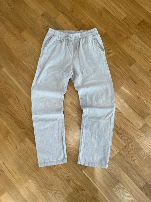 Beige linnebyxor från Kappahl - Snygga beige linnebyxor från Kappahl med avslappnad passform och resår i midjan. Byxorna har raka ben och sidofickor, perfekta för en chill och stilren look. Tillverkade i ett luftigt linnematerial som känns skönt mot huden. Byxorna är i storlek 170/S. Skriv om du undrar något!
