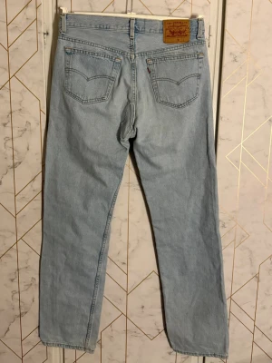 Levi's ljusblå raka jeans - Klassiska ljusblå jeans från Levi's med rak passform och femficksmodell. Modell 423. Storlek W34 och L34. Baken är lagad annars bra skick. Osäker på storleken. Står nummerna  790cs 17 och 913 och 520 04 93 20156-4 och 501 och -0134 på lappen.