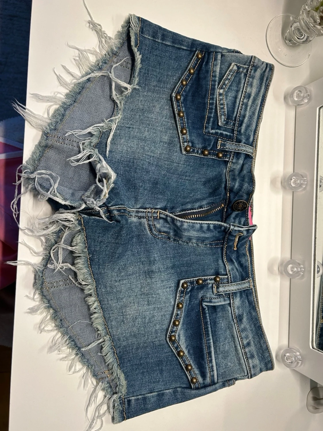 Blå jeansshorts med nitar och fransar