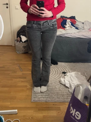 Bootcut jeans - Gina Young - Jag säljer mina supercoola, gråsvarta jeans från Gina Young som jag har pyntat med gnistrande stenar för en helt unik look! • Design: Jag har själv satt dit stenarna med starkt tyglim på bakfickorna, utformade som snygga stjärnor. Perfekt för dig som vill ha något som ingen annan har! • Passform: Bootcut/Flare-modell som sitter riktigt snyggt.