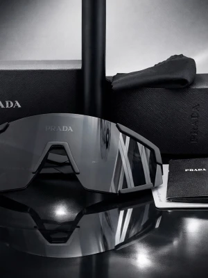 Prada 23053 Sport Shield - Säljer ett par exklusiva Prada 23053 solglasögon i sportig shield-design, helt i nyskick.  ✨ Detaljer 	•	Modell: Prada 23053 	•	Färg: Svart / mörk lins 	•	Storlek: 55□17–142 mm 	•	Stil: Sport / futuristisk shield 	•	Inkluderar: Originalkartong, hårt fodral, putsduk & garantikort 	•	Tillverkade i Italien 55 → Glasbredd (55 mm) 	•	17 → Näsbrygga (17 mm) 	•	142 → Skalmens längd (142 mm) Skick: Nästan oanvända, inga repor eller märken.  Perfekta för dig som vill ha både trendig design och funktio