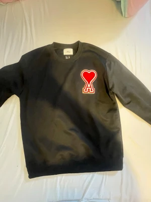 Svart tröja  från Ami Paris - Hej säljer en svart Ami Paris tröja.Tröjan är helt ny bara provad utan etiketen tröjan är i perfekt skick pris.tröjan kommer även med sitt  Påse.tröjan är I size L kan även skicka mer info privat så det är bara att skriva.Pris 400kr går att förhandla