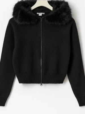 Svart stickad hoodie med fuskpäls - Cool svart stickad hoodie med dragkedja och fluffig fuskpäls runt huvan. Tröjan har ribbade muddar och är lite kortare i modellen, perfekt att matcha med jeans. Materialet är mjukt och varmt, idealiskt för kyliga dagar. Säljs inte längre och har lappen på.💕