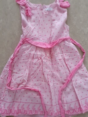 Klänning - Söt rosa klänning från Charter Club med små blommiga mönster och dekorativt knytband i midjan. Klänningen har ärmar med rosett-detaljer och är tillverkad i mjuk bomull med foder i bomull och polyester. Perfekt för sommarens alla tillfällen!