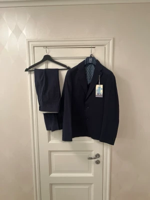 Oanvänd Harry Brown kostym 48 marinblå nypris 4500 kr - Säljer en stilren marinblå kostym från Harry Brown.  Nypris: 4 500 kr Mitt pris: 1 695 kr  Helt ny och aldrig använd. Storlek: 48  Tidlös modell som passar perfekt till student, bröllop, bal, examen eller jobb. En klassisk marinblå kostym som fungerar året runt.  Kan fraktas eller provas i Sollentuna. Fler kostymer finns i andra storlekar och märken. Hör av dig vid intresse!