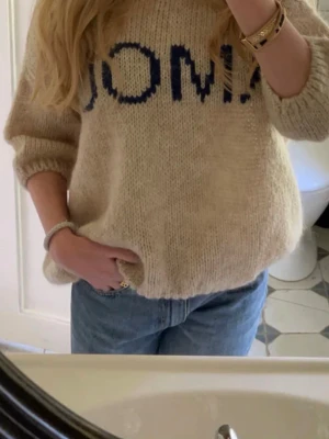 Beige stickad tröja med blå text - Jättefin trekvartsärmad stickad från design by si! Använd 2 gånger🥰 str M-L men passar mig som brukar ha S-M!💖