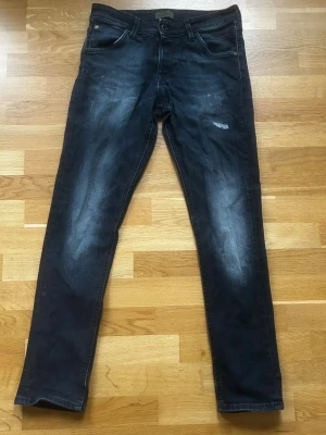 Jack and Jones Jeans med slitningar  - Säljer ett par riktigt fräscha svarta  jack and jones jeans med slitningar endast för 449kr!                                                                             Nypris:999kr därav väldigt bra erbjudande.                                                                    Har några frågor är det bara att fråga på!