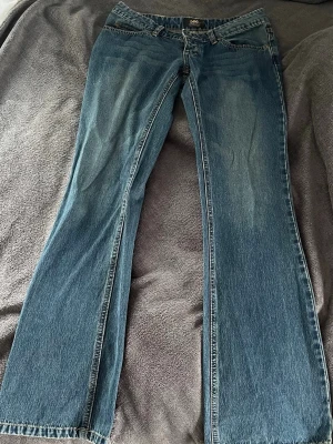 Blå bootcut jeans från Lee - Säljer ett par klassiska blå bootcut jeans från Lee  Jeansen har låg midja. Det är i mycket bra skick i storlek 32!