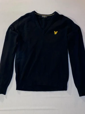 Svart stickad tröja - Stilig finstickad tröja från LYLE & SCOTT. En stretchig övertröja med v-ringad krage som passar perfekt över en skjorta.