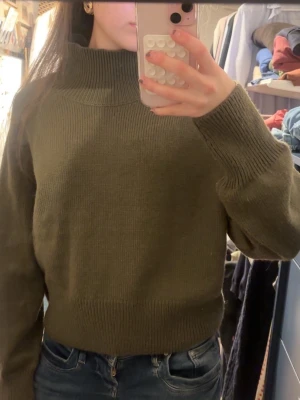 Olivgrön stickad polotröja - Säljer en olivgrön stickad polotröja med hög krage och långa ärmar. 