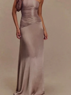 Champagnefärgad axelbandslös långklänning - Snygg axelbandslös långklänning i champagnefärgad satin med figurnära passform upptill och lätt utsvängd kjol. Klänningen har draperade detaljer över midjan och en elegant, slät finish. Perfekt för dig som vill ha en stilren och trendig look. Jag köpte den i storlek M men lät en skräddare sy om den till S.