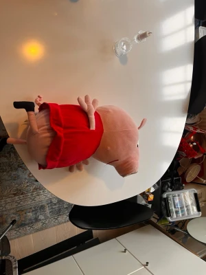 Stor Peppa Pig mjukisdjur - Säljer ett stort mjukisdjur föreställande Peppa Pig. Gosedjuret är rosa med en röd klänning och svarta skor. Perfekt som present till någon som gillar tecknade figurer eller vill ha en mysig kompis i soffan.