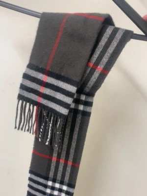 Grå rutig halsduk med fransar - Snygg grå halsduk från burberry. Perfekt accessoar för att lyfta din outfit under kyliga dagar.