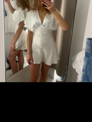 Vit omlottklänning med v-ringning - Helt ny vit kläning från Gina tricot i storlek xs. Aldrig andvänd då jag skulle ha den på skolavslutningen men köpte en annan och det går ej att lämna tillbaka längre!!