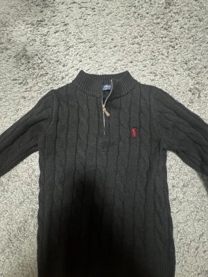Svart polo halfzip  - Polo med halvzip i storlek S. Plagget har tyvärr krympt något i tvätten och upplevs därför som något mindre i storleken, passar bäst XS eller en liten S. I övrigt i gott skick utan fläckar eller hål. Perfekt för en stilren och avslappnad look.