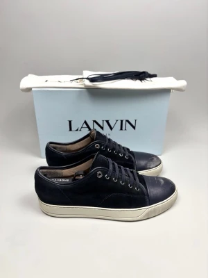 Lanvin DBB1 Sneaker Navy - Lanvin DBB1 Sneaker Navy | Modell: DBB1 | Skick: Begagnat skick (slitage finns, se bilder) | Nypris: 4999 kr | Storlek: 9 UK / 43 EU | Creaseskydd sitter i skorna och redo att användas | Skobox, extra skosnören och dustbags medföljer | Hör av dig vid minsta fundering 📦