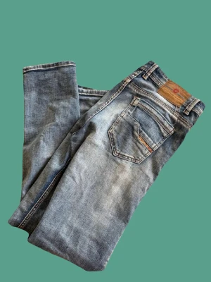 Blå bootcut jeans från Mastino Jeans - Snygga blå herr raka jeans från Mastino Jeans med klassisk femficksmodell och slitna detaljer. Jeansen har en ljus tvätt och läderpatch bak i midjan. Tillverkade i bomull med en avslappnad passform och raka ben. Storlek 44/30 men passar på mig som är 172 och väger 65kg.