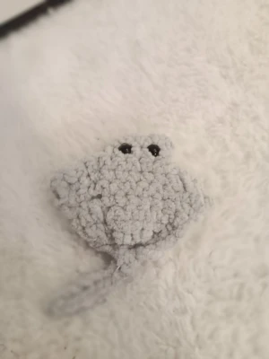 Virkad grå rocka i mjukt garn - Handgjord liten rocka virkad i ljusgrått, fluffigt garn med svans och svarta ögon. Undersidan är vit och mjuk. Perfekt som dekoration, leksak eller present till någon som gillar havsdjur och söta figurer.