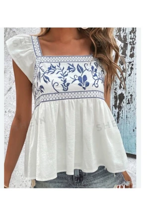 Vit blus med blå broderier från SHEIN - Supersöt vit blus från SHEIN med blå broderade blommor och rutmönster upptill. Blusen har korta ärmar, fyrkantig ringning och en luftig, flowy passform. Perfekt till sommaren och passar till både jeans och kjol. Perfekt för sommaren och väldigt fin för midsommar 