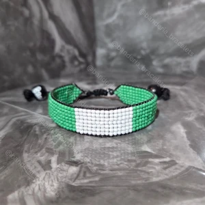 Nigerianska flaggan Handgjort Armband - ✨️Justerbart, enkelt att öppna och stänga ✨️Kan stängas till en 15cm omkrets och öppnas bredast till ca 27cm omkrets ✨️Höjden av flagg-delen är 1,3cm ✨️Flagg-delen minus knuten är 14cm lång ✨️Skickas inom en vecka så fort tillverkningen är klar