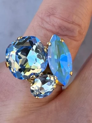 Mixed sized ring Blå nyanser  - Mixed sizes ring i guldpläterad mässing med Square 12x12mm, oval 8mm och Navette 15mm. Färg, Summer Blue De Lite och Light Sapphire. Ställbar storlek. Sista bilderna visar olika färgkombinationer och modeller.  Jag skickar endast spårbart, samfraktar. Fast pris. Besök gärna mina övriga annonser.  Till mina smycken använder jag kristaller från Preciosa, Aurora och Swarowski.