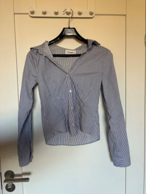 Randig blå figursydd skjorta   - Blå- och vitrandig figursydd skjorta från Pull&Bear storlek M