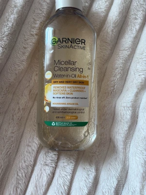 Garnier Micellar Cleansing Water-in-Oil - Micellär rengöring från Garnier för torr och mycket torr hud. Tar bort vattenfast mascara, rengör och mjukgör huden utan att behöva sköljas av. Innehåller vårdande arganolja. Transparent plastflaska med gul olja, 400 ml. Använt fåtal gånger. Se bild för mängd 💛 liten extra gåva vid varje köp! Skickar allt omsorgsfullt i bubbelplast & kartong