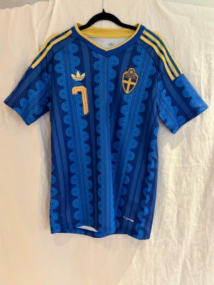 Sveriges 2026 vm bortatröja Bergvall #7 - Sveriges borta tröja som de ska spela vm i till sommaren! Det var en sån här tröja dem spelade i när dem slog ut Ukriana i playoff semi finalen! På ryggen gömmer sig Lucas Bergvall!