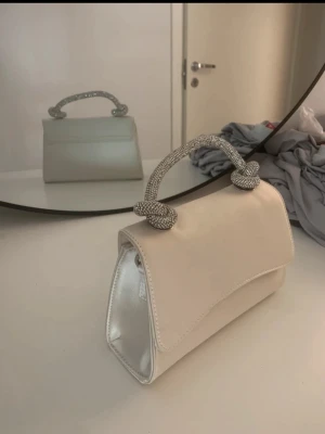 Vit kuvertväska med glittrigt handtag - Vit glittrig väska