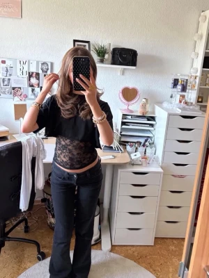 Svarta Bootcut jeans med låg midja  - Säljer ett par svarta jeans med bootcut passform och låg midja. Jeansen har klassisk femficksdesign och knappgylf. Perfekta för dig som gillar en tidlös och trendig look.🥰💕