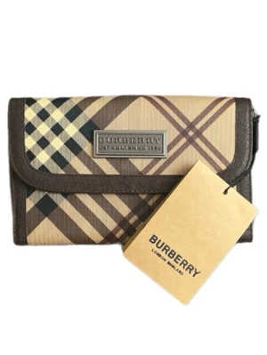 B Berry beige hand väska med rutmönster - Snygg beige hand väska från B Berry med det klassiska rutmönstret i brunt, svart och vitt. Plånboken har en rektangulär form, bruna kanter och ett metallmärke med Burberry-loggan på framsidan. Tillverkad i canvas med detaljer i konstläder.