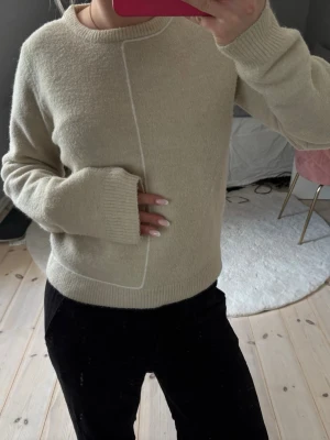 Beige stickad tröja med vit detalj - Beige stickad tröja från Zara med stretchig passform och mjukt material. Nästan aldrig använd. Storlek M men passar även mig som har XS/S 💕 pris kan diskuteras 