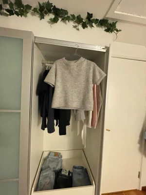 Grå stickad tröja från Gina Tricot - Säljer en ljusgrå stickad tröja från Gina Tricot i storlek 146/152. Tröjan har korta ärmar, rund halsringning och är gjord i ett mjukt, mysigt material. Perfekt för en avslappnad och trendig look.