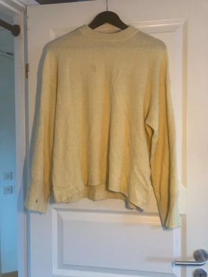 Gul oversized  tröja - Mysig oversized  tröja i ljusgul färg med rund halsringning och långa ärmar. Tröjan har breda ribbade muddar vid ärmsluten och en avslappnad passform som passar perfekt till jeans eller kjol.