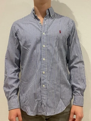 Randig skjorta från Ralph Lauren - Ralph Lauren skjorta || Storlek M (Classic Fit) || Skjortan är i bra skick, däremot förekommer en fläck på kragen (de bild 5) || Modellen på bilden är 170cm och väger 62kg || Tveka inte på att höra av dig vid frågor eller funderingar 