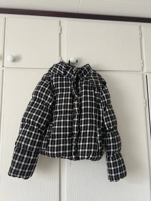 Rutig kort  jacka ganska tjock - Jacka från New Yorker, varm och använd. Svart/vit/brun rutig. Den är sydd i armhålan då sömmen har gått upp där men försämrar inte användningen. Köparen står för frakt!☺️