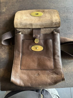 Vintage Mulberry väska - Snygg brun axelväska i äkta läder från Mulberry med klassiskt vridlås i mässing. Väskan har en justerbar axelrem i textil och ett stort ytterfack med Mulberrys ikoniska trädlogga.